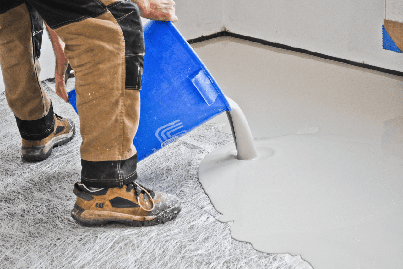 Flooring specialist pouring liquid floor screed